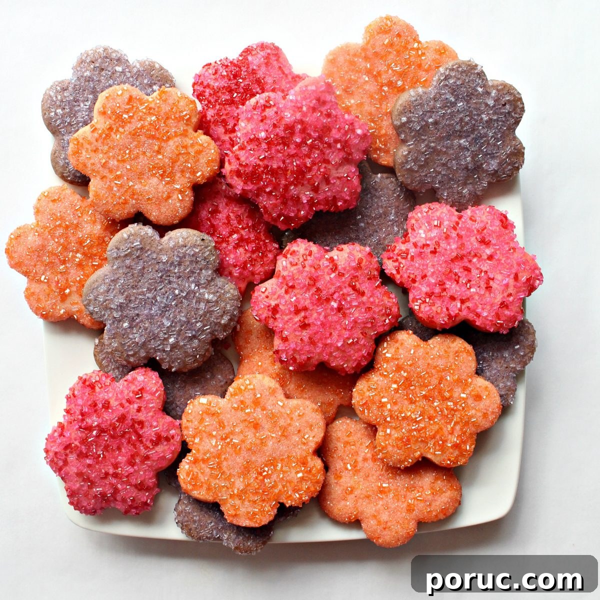 Jam-Filled Butter Cookies Recipe: Crispy, Buttery Thumbprints 6 Flower shaped cookies on a square white serving platter.