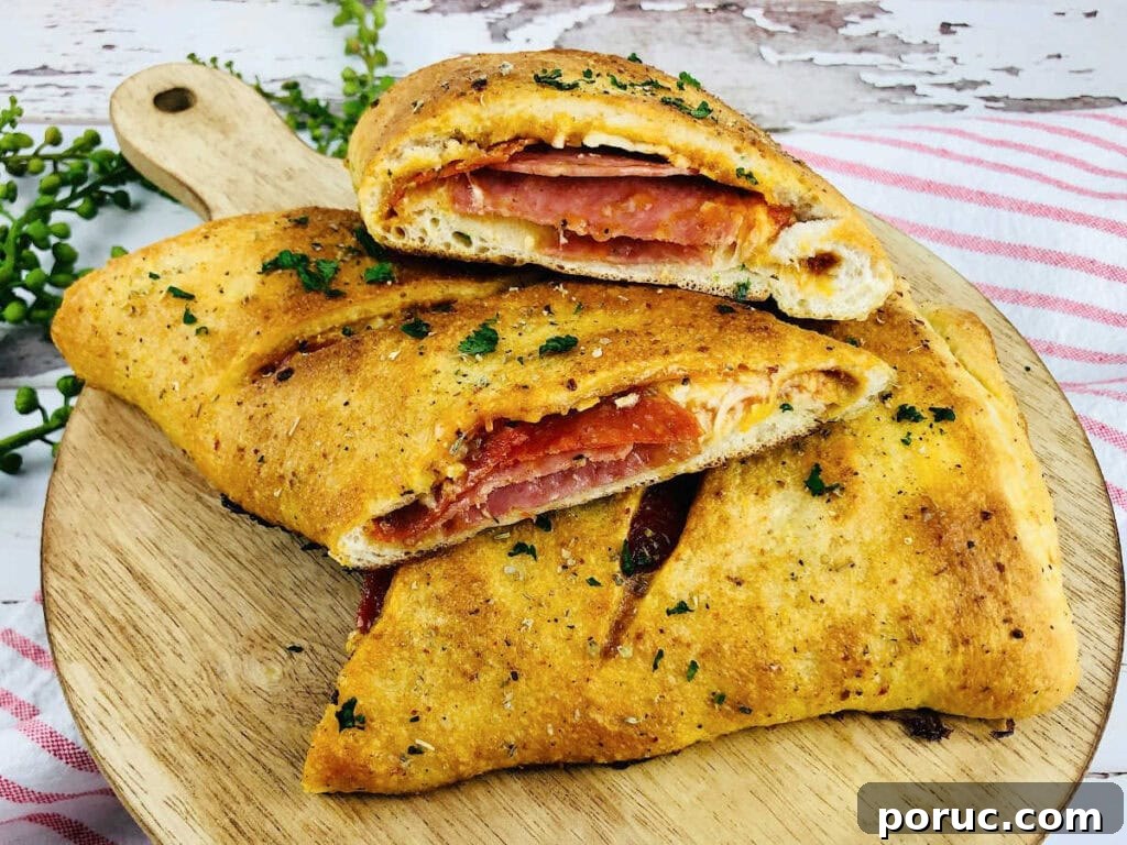 Authentic Italian Stromboli Recipe: Crispy, Flavor-Packed Roll 7 Three slices of easy Italian Stromboli on a round wooden cutting board.