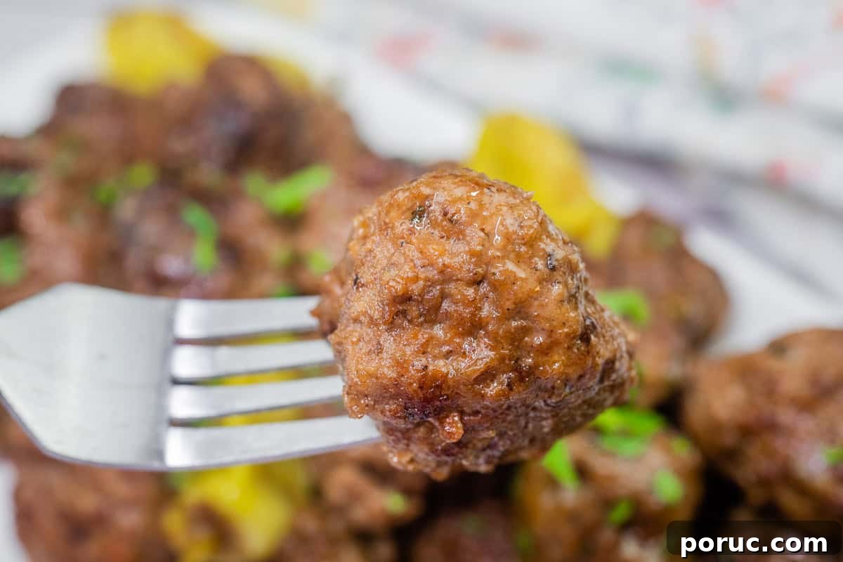 25 Comfort-Food Recipes That Satisfy Every Craving 12 A close-up of a meatball on a fork, with more meatballs in the background.
