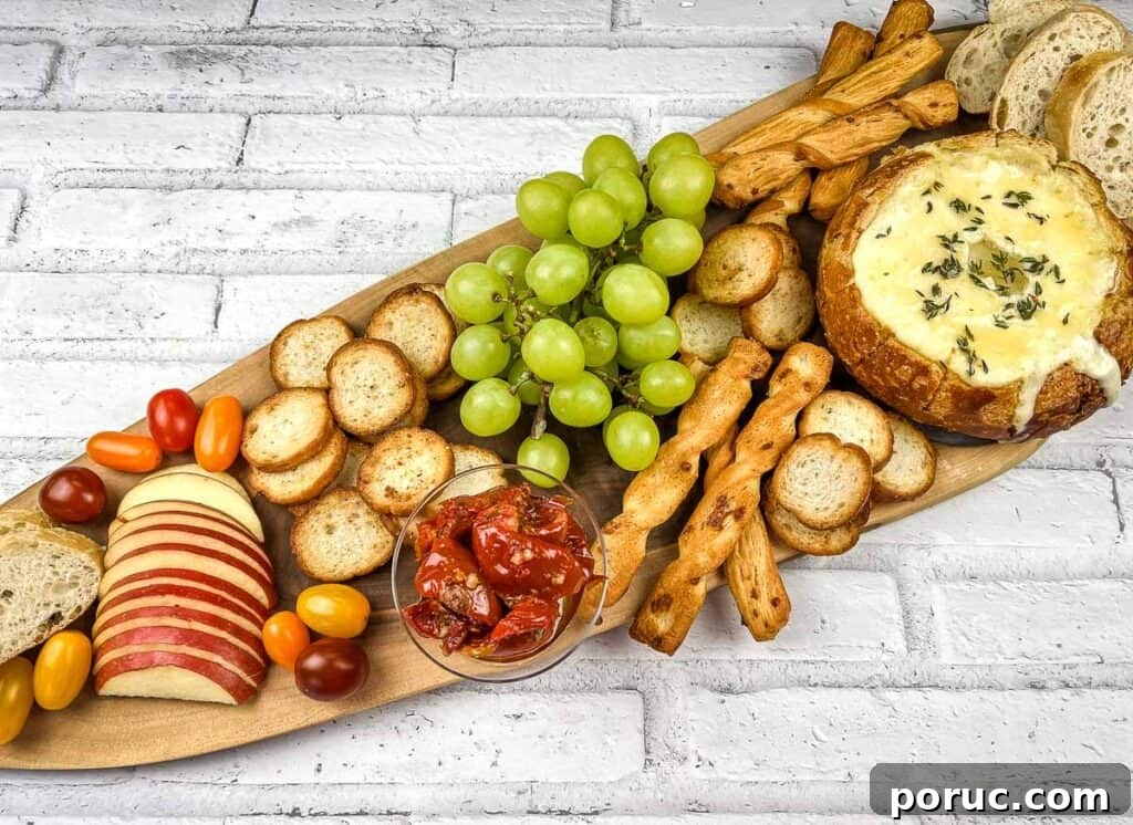 25 Comfort-Food Recipes That Satisfy Every Craving 14 A wooden platter with baked brie in a bowl, cheese, crackers, grapes and bread.