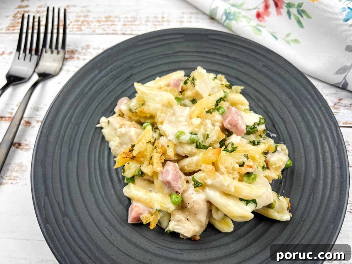 25 Comfort-Food Recipes That Satisfy Every Craving 17 Chicken cordon bleu casserole on a black plate with a fork.