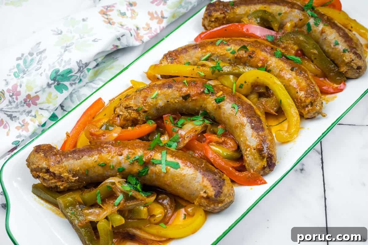 25 Comfort-Food Recipes That Satisfy Every Craving 6 Five cooked Crock Pot Sausage and Peppers served on a white rectangular dish, garnished with chopped herbs.