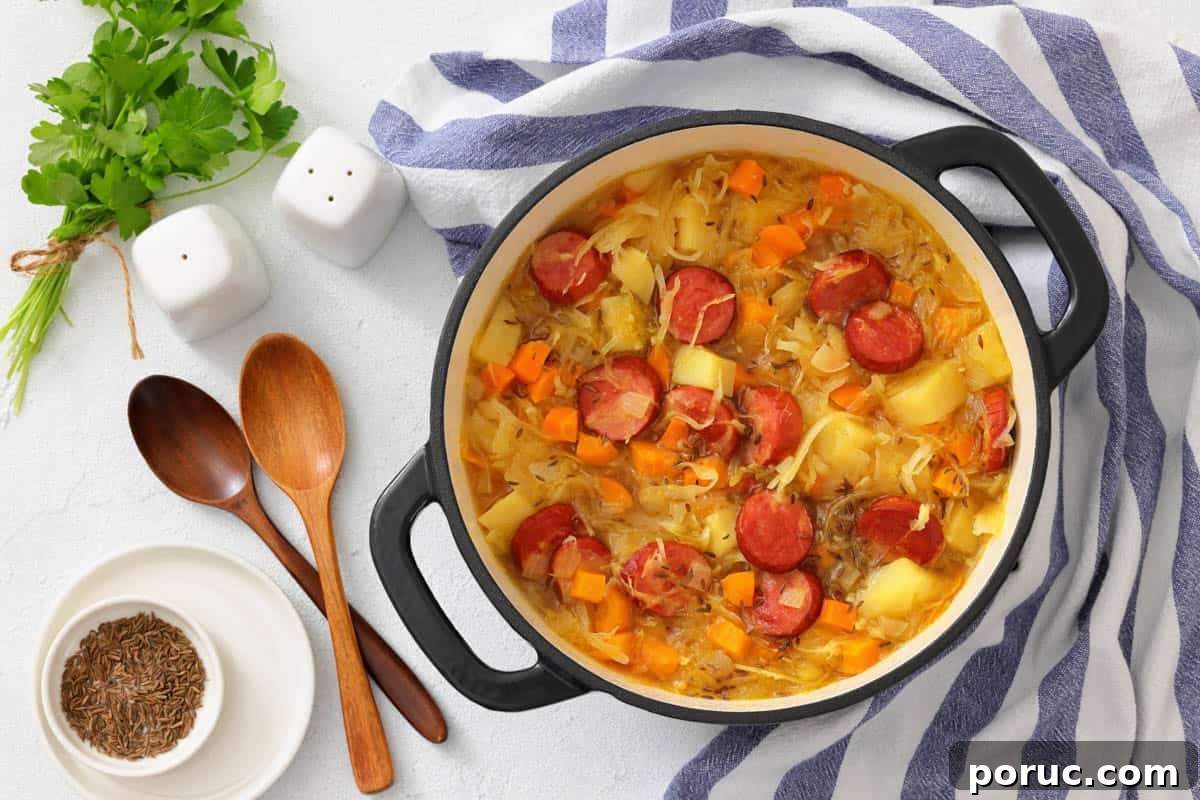 25 Comfort-Food Recipes That Satisfy Every Craving 10 A pot of Chef Jenn’s Sauerkraut Soup with Kielbasa sits on a striped towel next to wooden spoons, bowls, fresh herbs, and salt and pepper shakers.