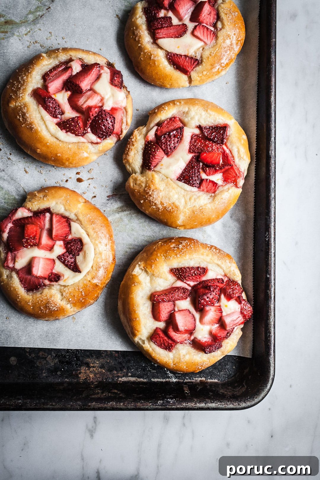 Strawberry Cream Cheese Brioche with Orange Blossom Water 12 Black pan of brioche pastries after baking, resting on a marble surface