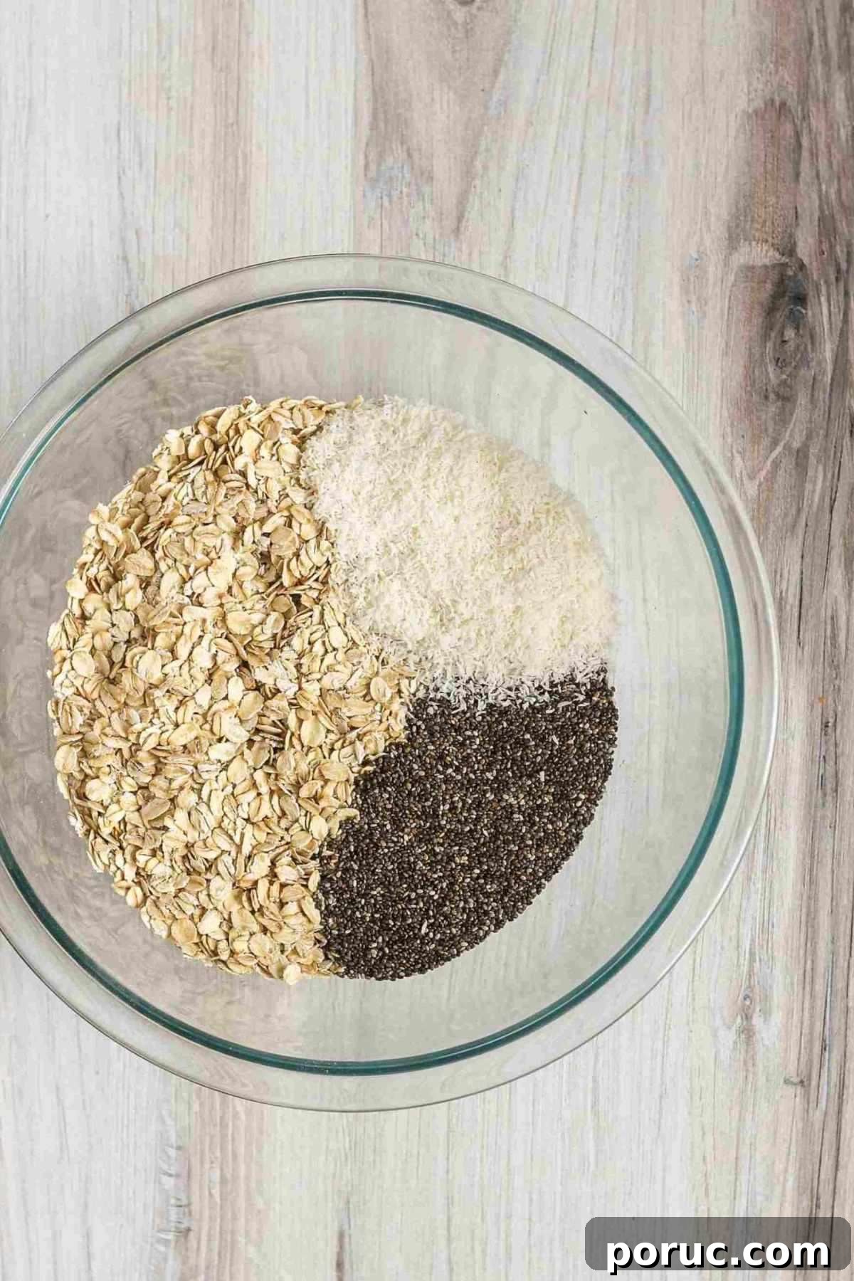 Chocolate Coconut Peanut Butter Energy Bites for Snacks 4 Oats, coconut flakes, and chia seeds in a glass mixing bowl.