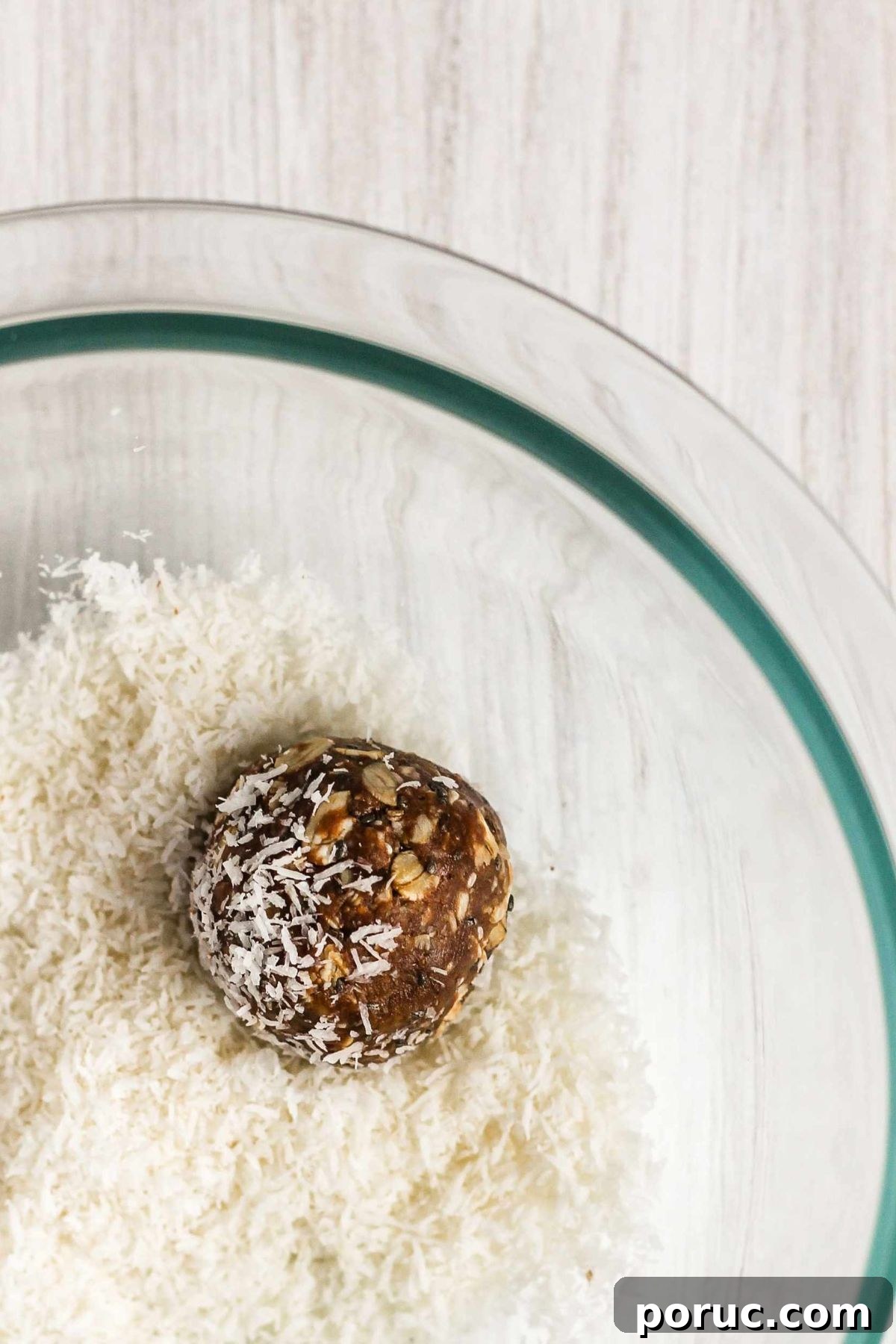 Chocolate Coconut Peanut Butter Energy Bites for Snacks 7 Single peanut butter chocolate at ball being rolled in a bowl of coconut flakes.