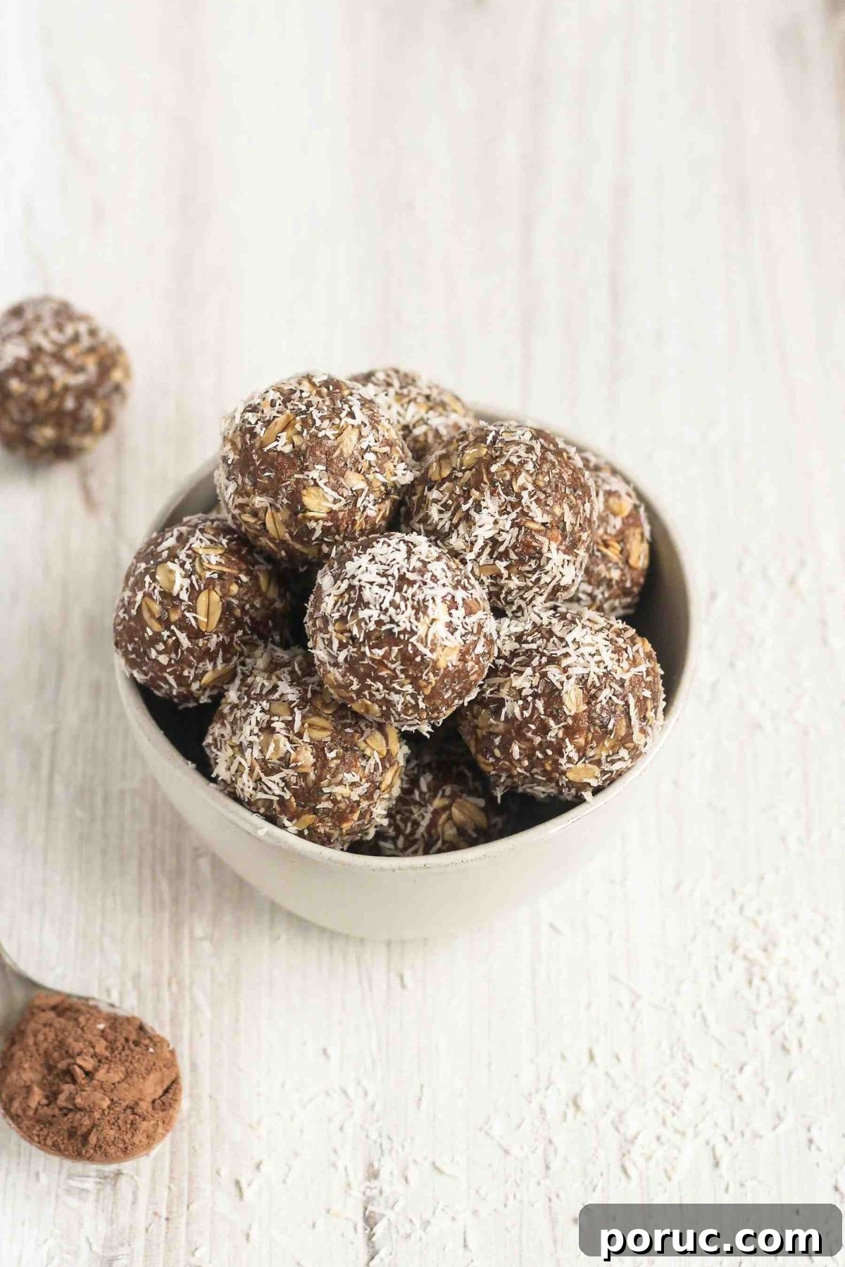 Chocolate Coconut Peanut Butter Energy Bites for Snacks 8 Peanut butter chocolate coconut balls stacked in a small bowl.