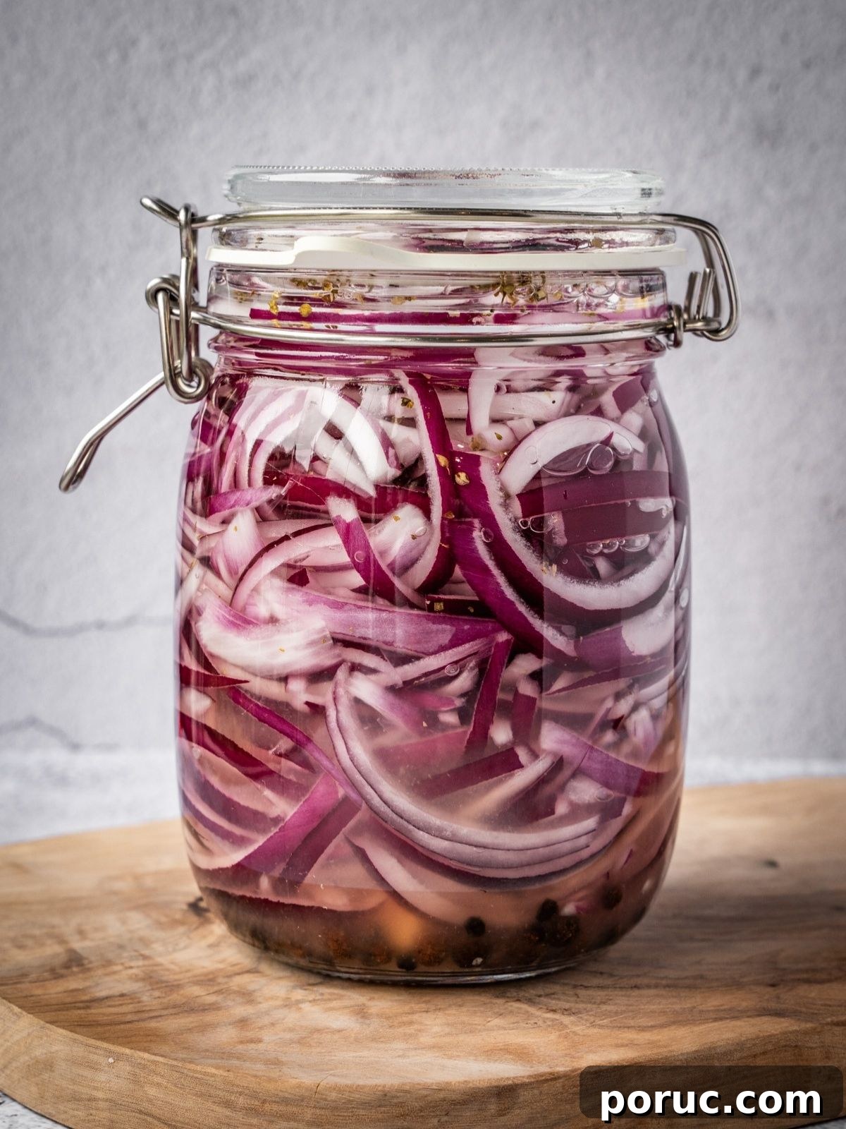 Yucatan-Style Mexican Pickled Red Onions for Tacos & Salads 11 A jar filled with sliced onions and brine.