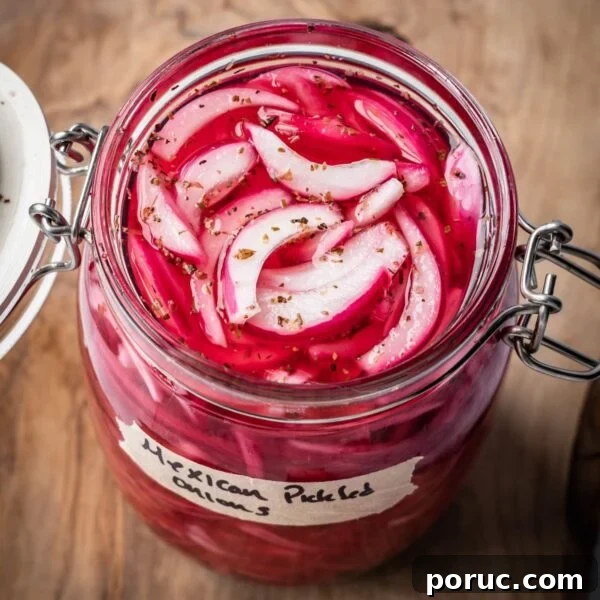 Yucatan-Style Mexican Pickled Red Onions for Tacos & Salads 14 An opened jar of pickled Mexican onions with a label on a wooden board.