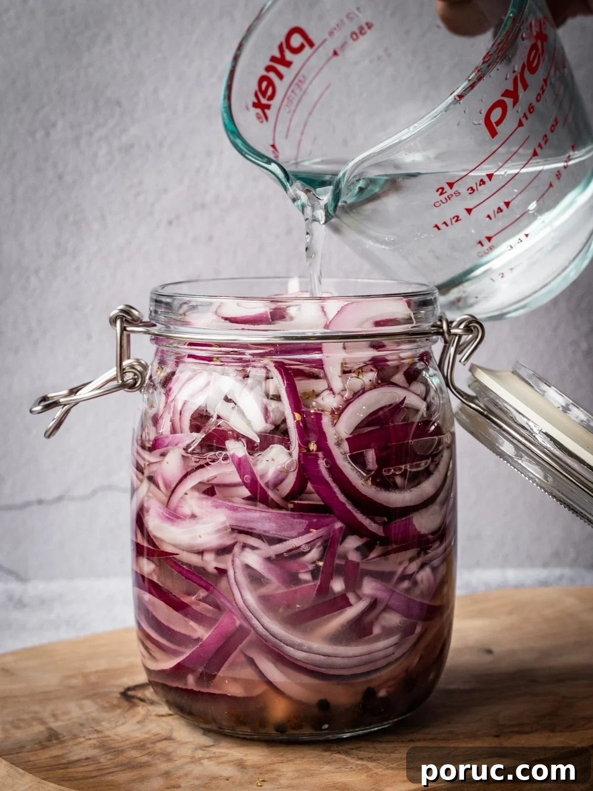 Yucatan-Style Mexican Pickled Red Onions for Tacos & Salads 10 Pouring pickling brine over the sliced onions.