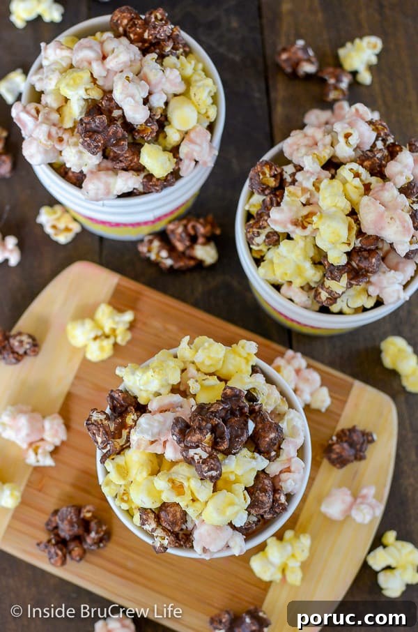 Banana Split Popcorn - this chocolate covered popcorn has chocolate, banana, and strawberry flavors all mixed together. Make a batch of this easy popcorn for movie nights. Overhead picture of three bowls of banana split popcorn on a wood background