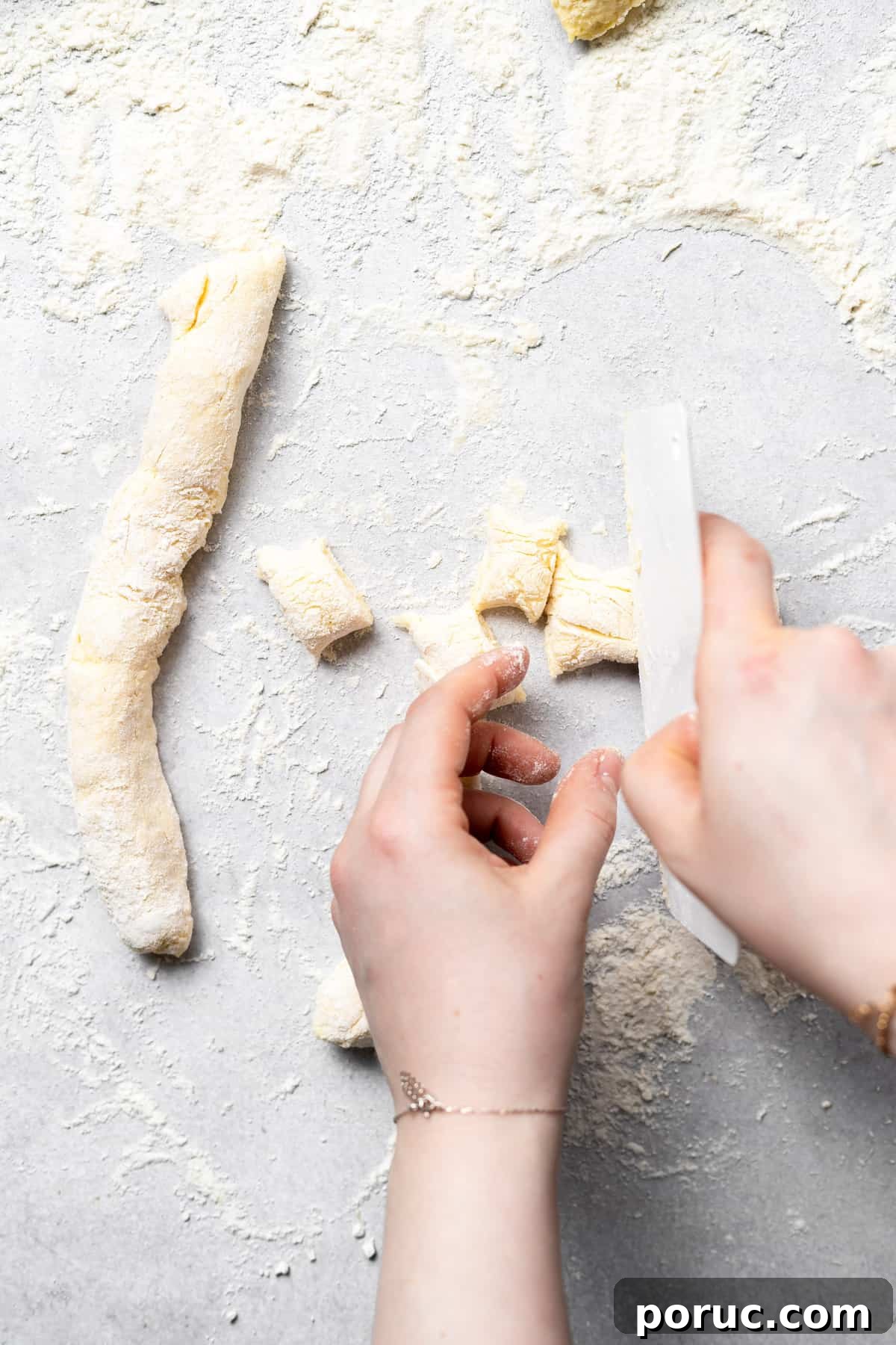 Cutting gnocchi into pieces ricotta gnocchi dough being cut into bite-sized pieces.