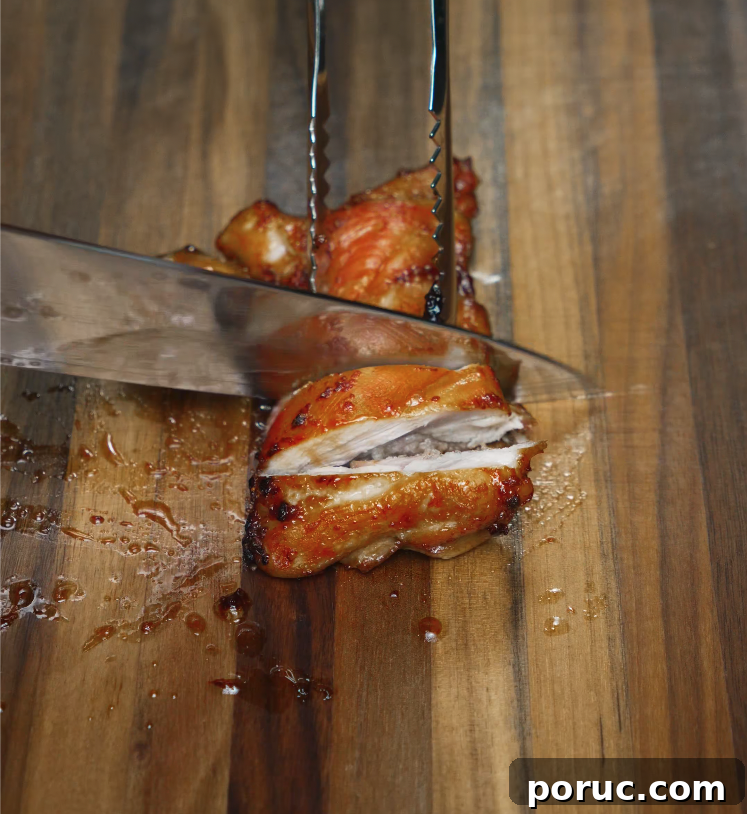 Korean Chicken Bulgogi Recipe: Sweet-Spicy Grilled Chicken 6 Juicy chicken bulgogi thigh being sliced on a wooden board after cooking, showing tender, caramelized meat.
