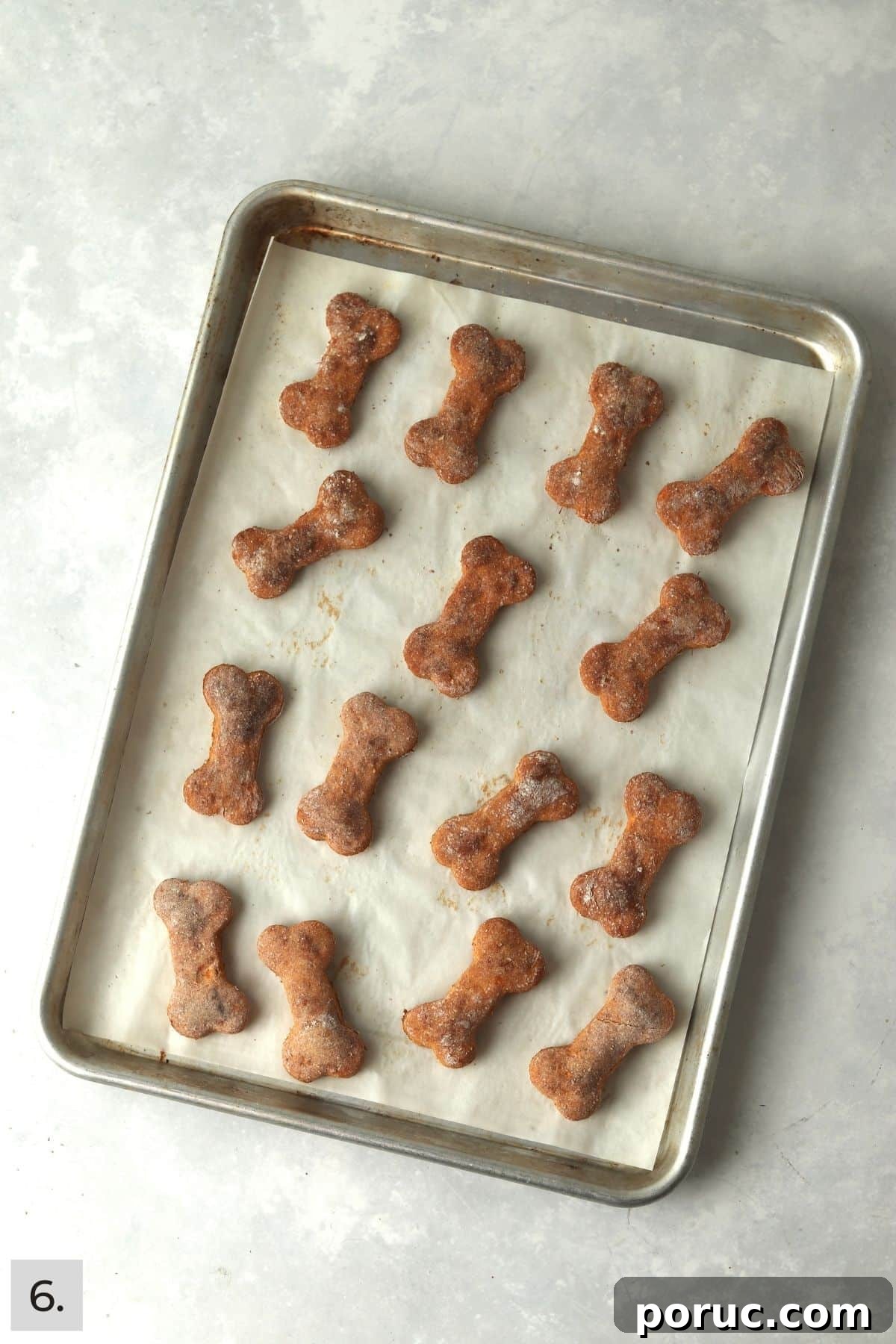 Baked Sweet Potato Dog Treats You Can Make at Home 9 Baked sweet potato dog treats cut into bone shapes on a baking sheet.