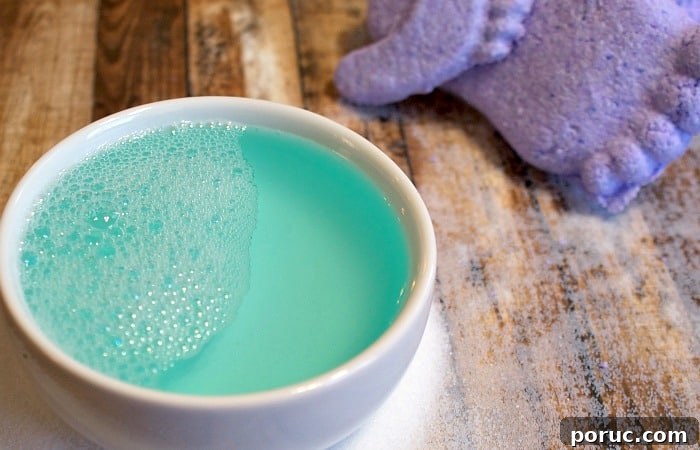 Mamma’s Famous Foot Exfoliation Elixir — Natural Foot Peel Recipe 3 A bowl of vibrant blue foaming liquid next to a purple exfoliating scrub, showcasing a homemade foot exfoliation elixir on a wooden surface.