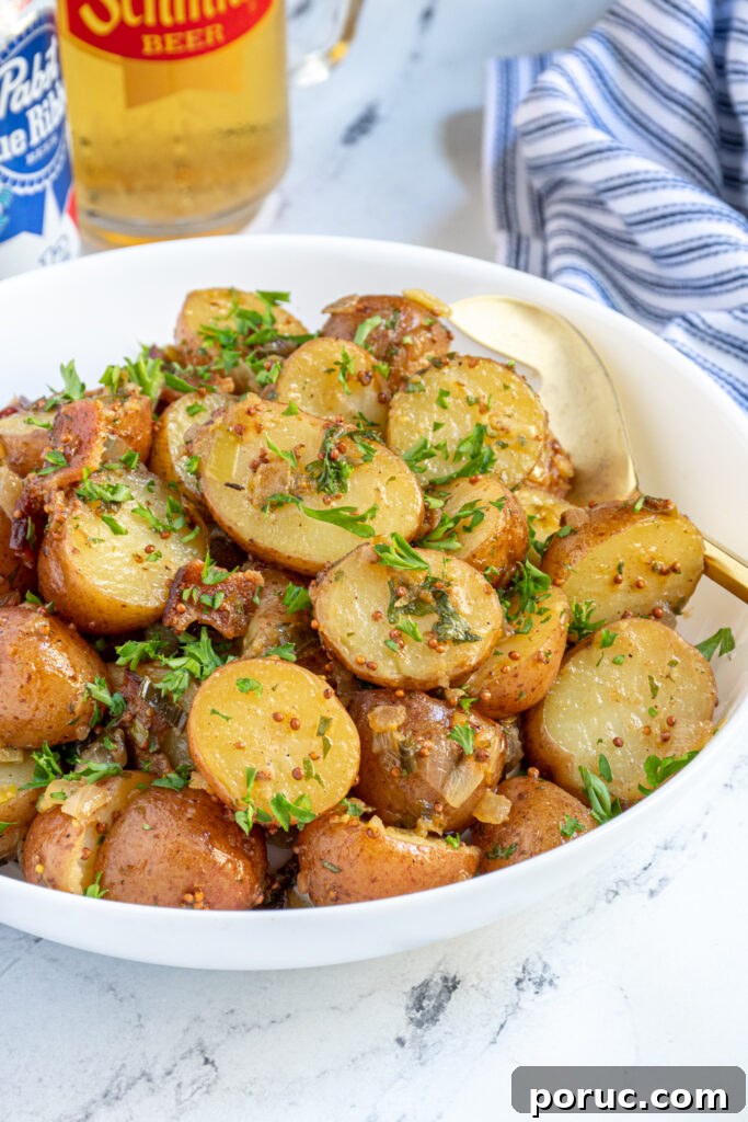close up of a bowl of German potato salad covered with bacon bits and fresh parsley.