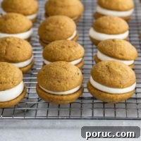 Mini Pumpkin Whoopie Pies with Cream Cheese Filling — Fall Dessert Recipe 9 mini pumpkin whoopie pies on a cooling rack