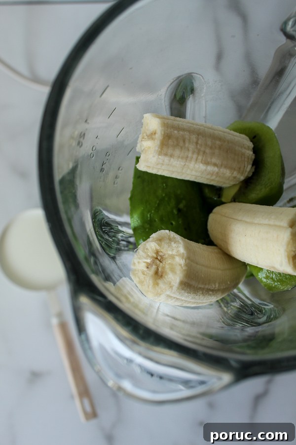 Creamy Kiwi Avocado Smoothie Recipe for a Refreshing Breakfast 3 Banana chunks, kiwi slices and an avocado in a blender.