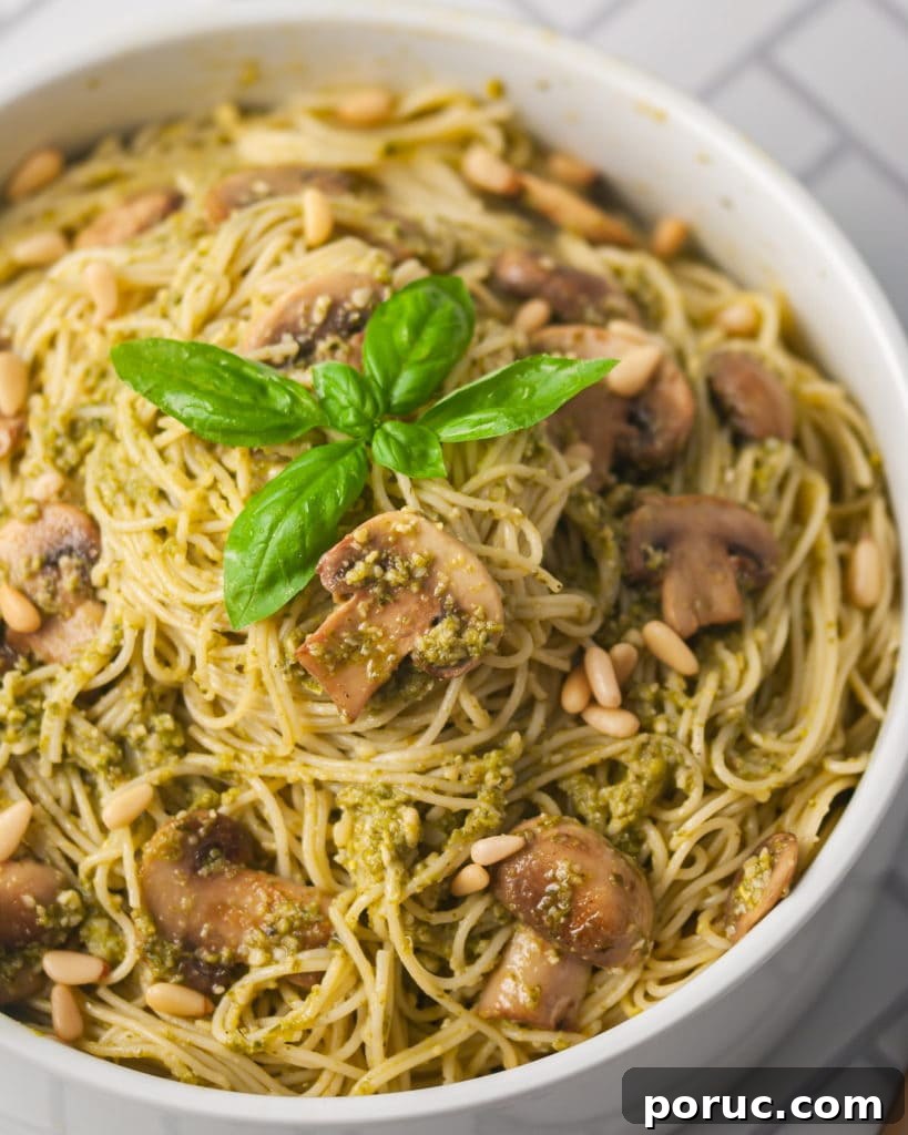 One-Pot Mushroom Pesto Pasta with 4 Ingredients 10 angled picture of angel hair pasta with pesto mushrooms and fresh basil on top
