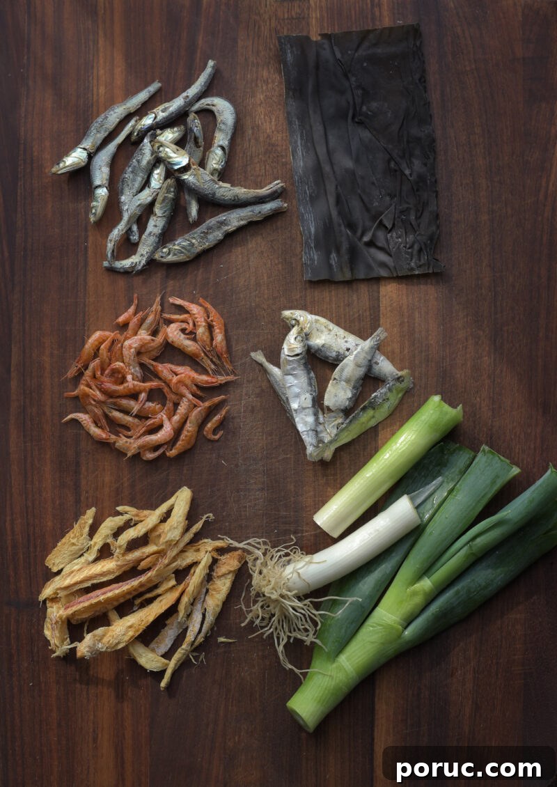 5 Essential Korean Soup Stocks for Authentic Korean Cooking 11 Various dried seafood and leek are displayed on a wooden board.