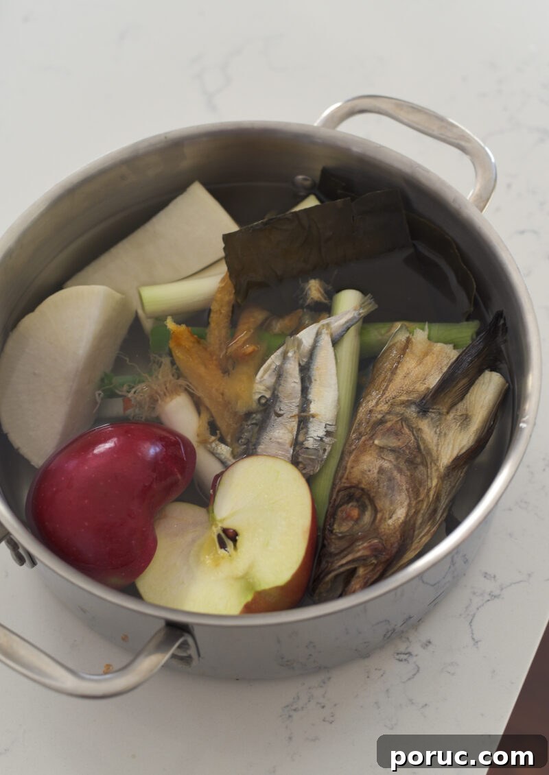 5 Essential Korean Soup Stocks for Authentic Korean Cooking 18 A big pot is filled with dried fish head, apple, radish, and other dried seafood in water.