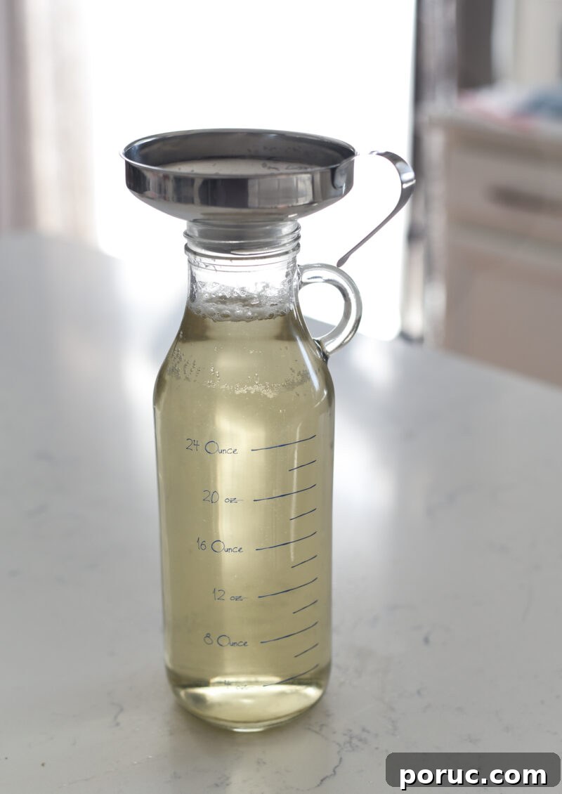 5 Essential Korean Soup Stocks for Authentic Korean Cooking 20 A glass bottle is filled with stock through a kitchen funnel on top.