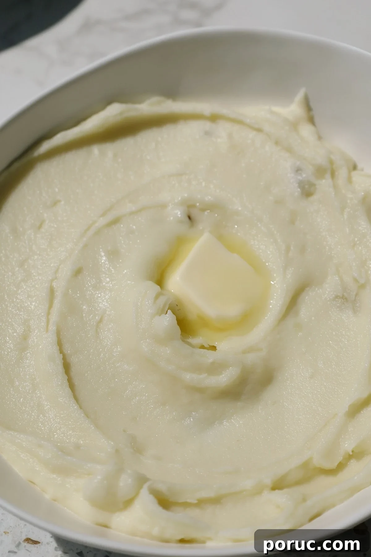 Creamy mashed potatoes with butter on top.