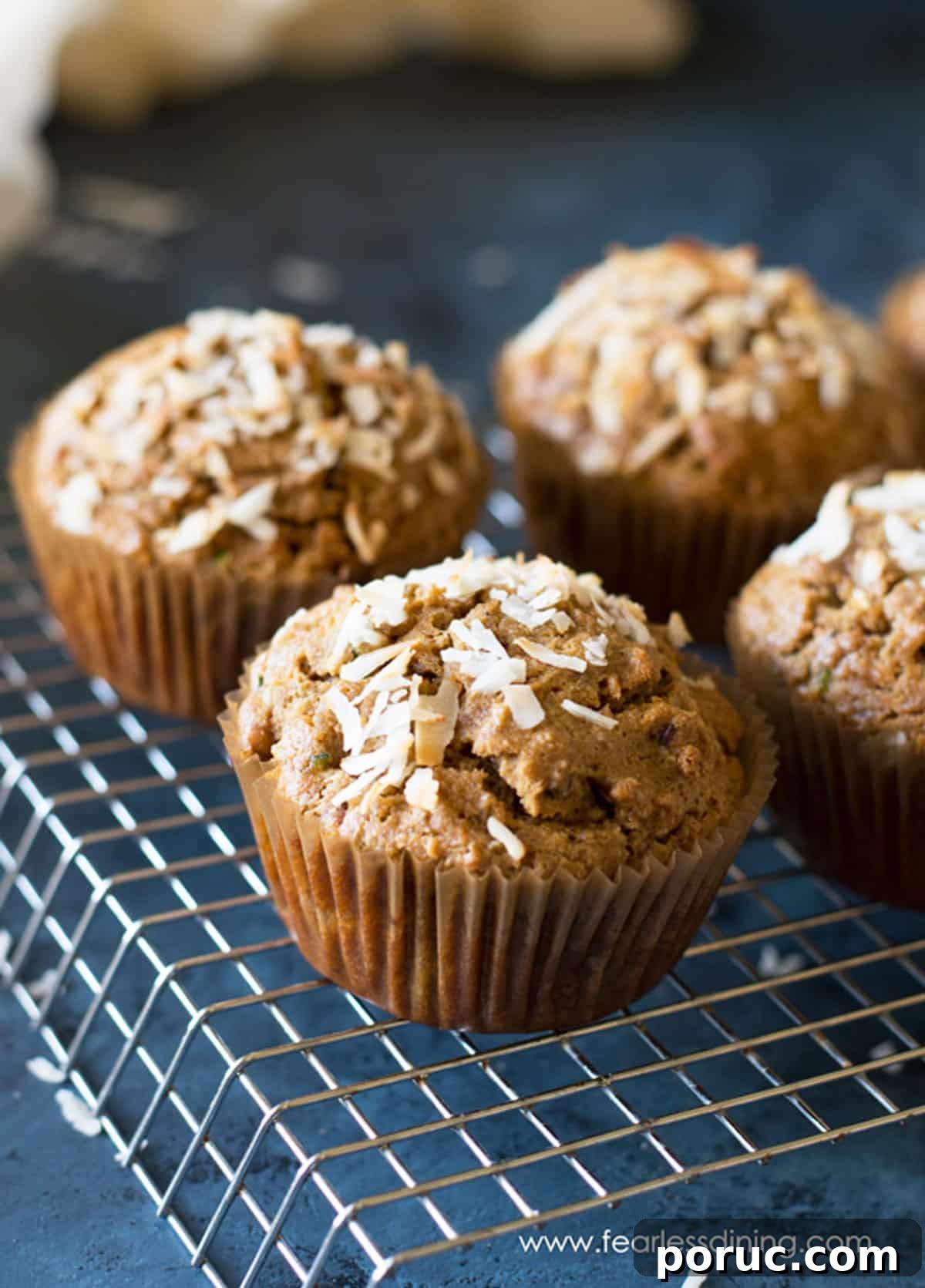 Gluten-Free Zucchini Muffins Kids Love — Dairy-Free Recipe 9 Four zucchini muffins on a wire rack.
