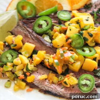 Jerk steak with mango salsa on a white plate with a bottle of Mazola heart healthy corn oil behind it