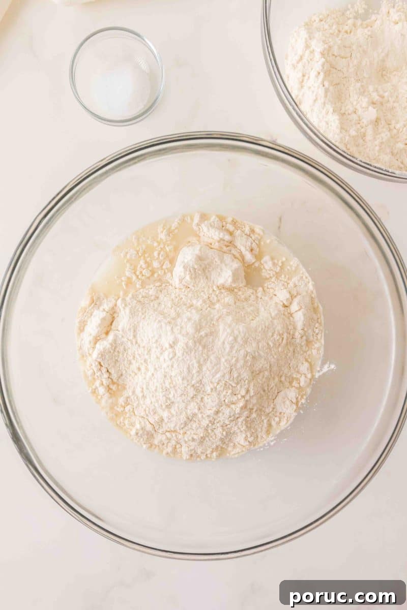 Sourdough Cinnamon Raisin Loaf — Soft, Sweet, Perfect Spice 5 Flour added to a milky mixture of water and sourdough starter in a mixing bowl. Hostess At Heart