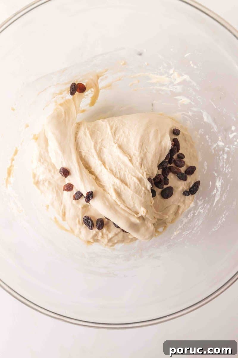 Sourdough Cinnamon Raisin Loaf — Soft, Sweet, Perfect Spice 8 Sticky sourdough bread dough in a mixing bowl with dark raisins folded throughout - Hostess At Heart