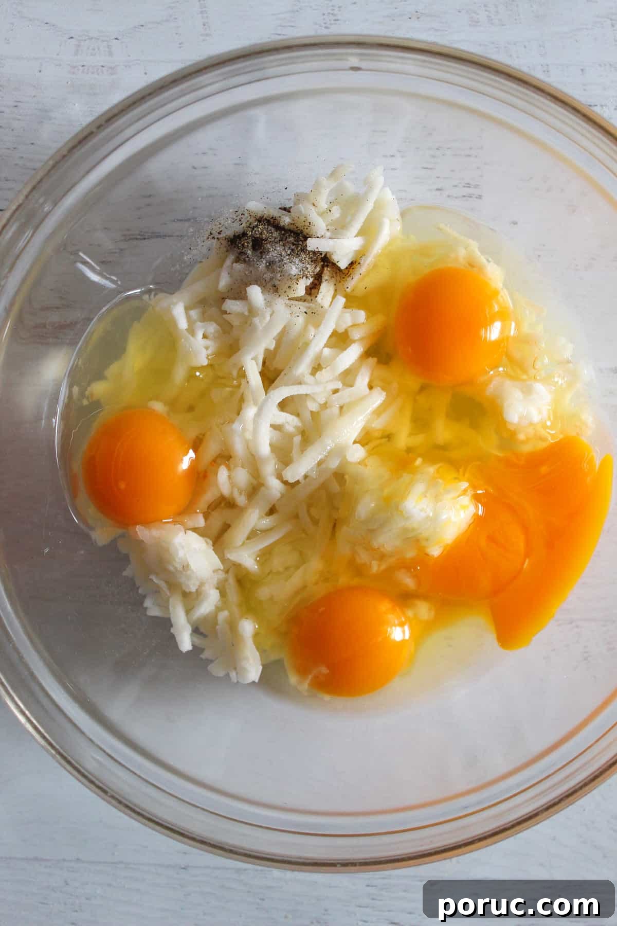 Meatless Gluten-Free Sausage Casserole Recipe for Busy Nights 7 egg, hash browns and milk in a glass bowl.