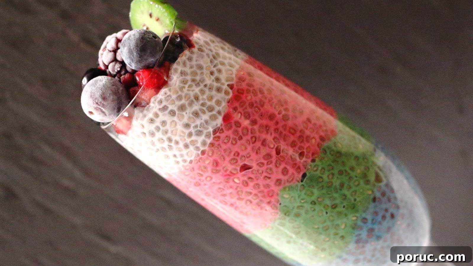 Rainbow Chia Pudding with dark background in a glass.