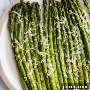 Crispy Air Fryer Asparagus Recipe — Quick Weeknight Side 7 air fryer asparagus topped with parmesan cheese on a serving plate