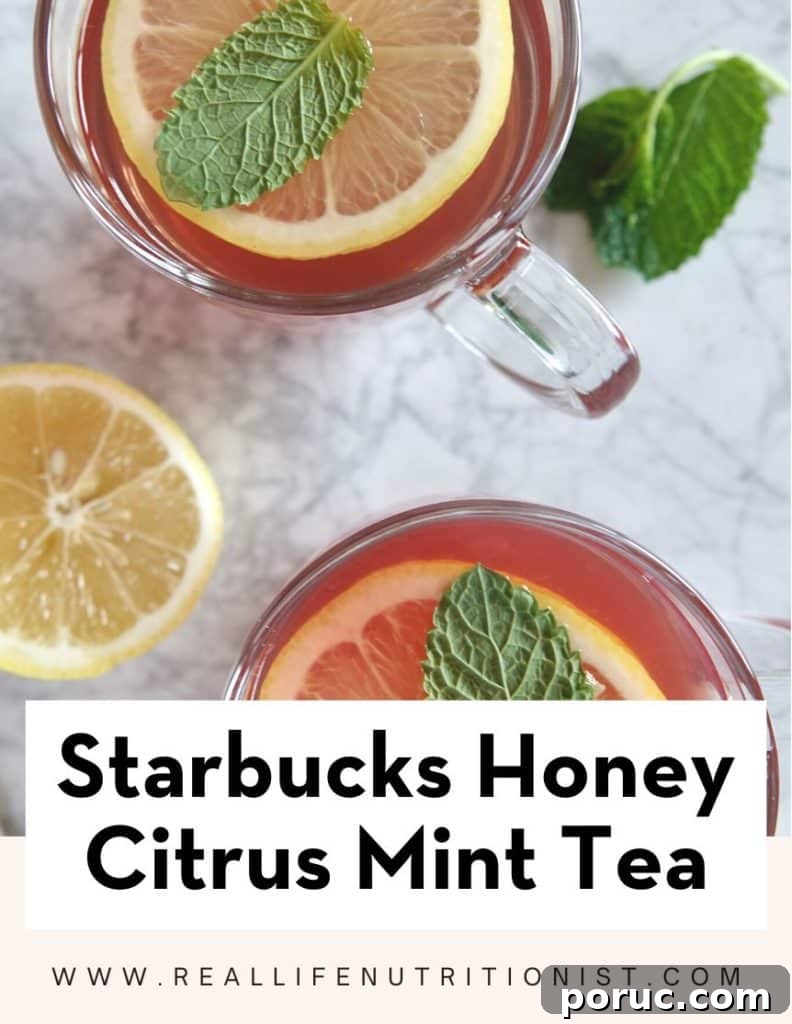 Honey Citrus Mint Tea — Copycat Starbucks Medicine Ball Recipe 6 Birdseye view of two mugs of tea on marble, garnished with lemon slices and mint. Text reads "Starbucks honey citrus mint tea"