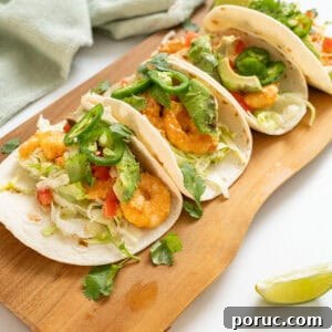 Volcano Shrimp Tacos: Spicy Grilled Shrimp with Lava Sauce 15 Volcano shrimp tacos on a cutting board topped with cilantro, tomatoes, jalapeno, and avocado.