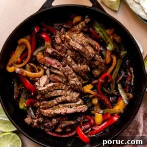 Sizzling Steak Fajitas Recipe with Peppers and Onions 9 Large cast iron skillet filled with sliced grilled steak and grilled bell peppers and onions.