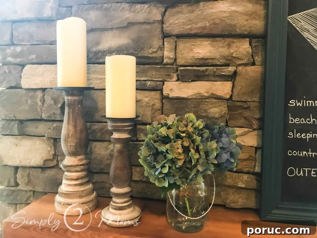 simple summer fireplace mantle close up of candle stick holder with mason jar filled with hydrangea