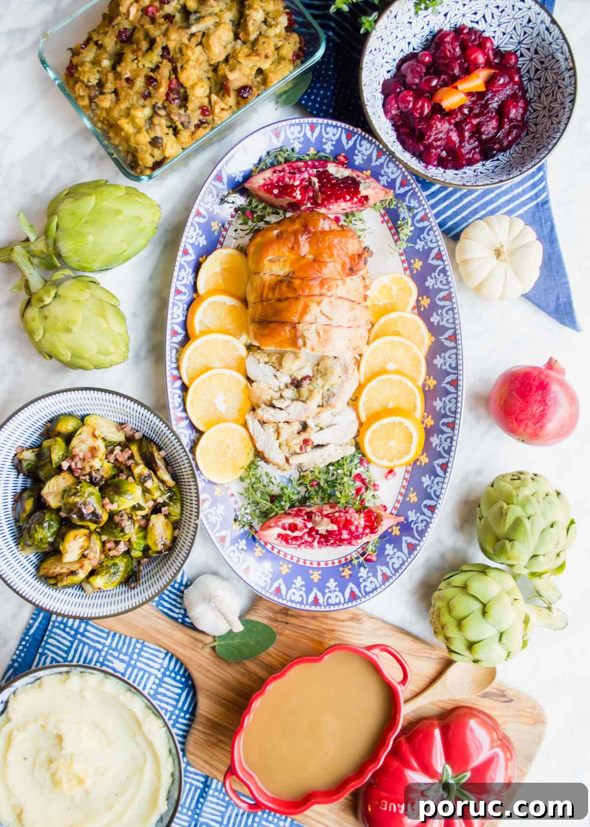 Turkey Au Jus Recipe — Savory Thin Gravy for Roast Turkey 3 Roasted Turkey Roulade on plate with lemons, Turkey Au Jus Gravy, and other sides flatlay.