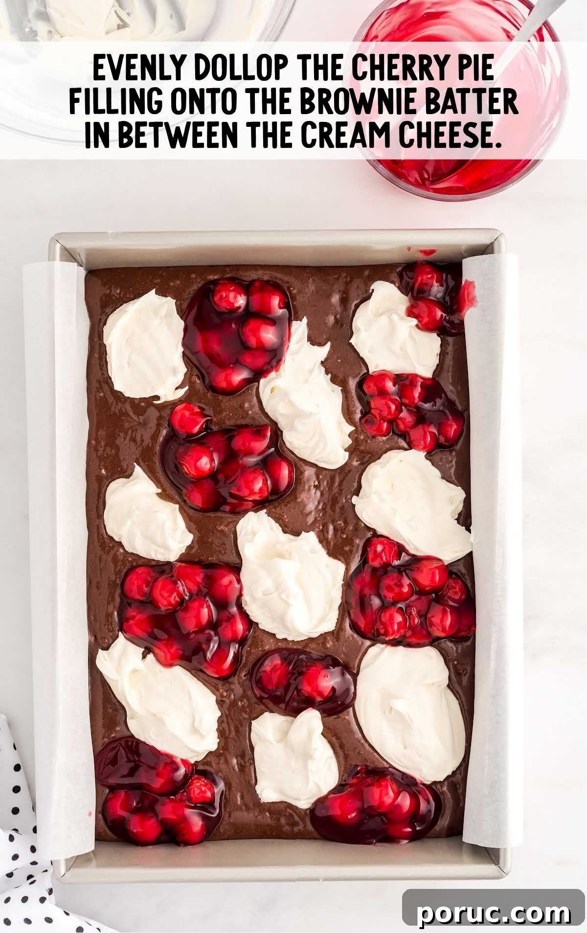 scoops of cherry pie filling placed on top of the brownie mixture