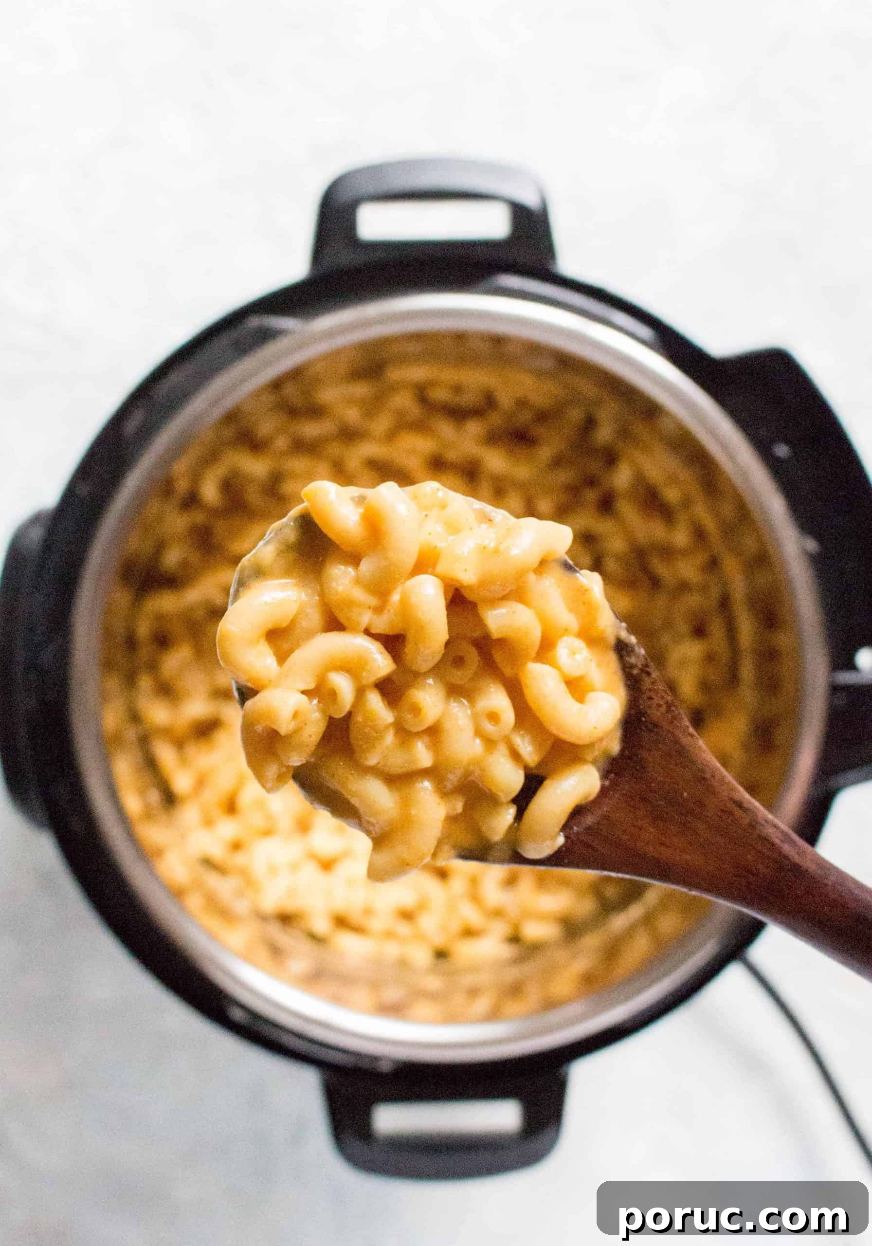 Creamy Instant Pot Macaroni and Cheese in 20 Minutes 5 A spoonful of mac and cheese over an instant pot.