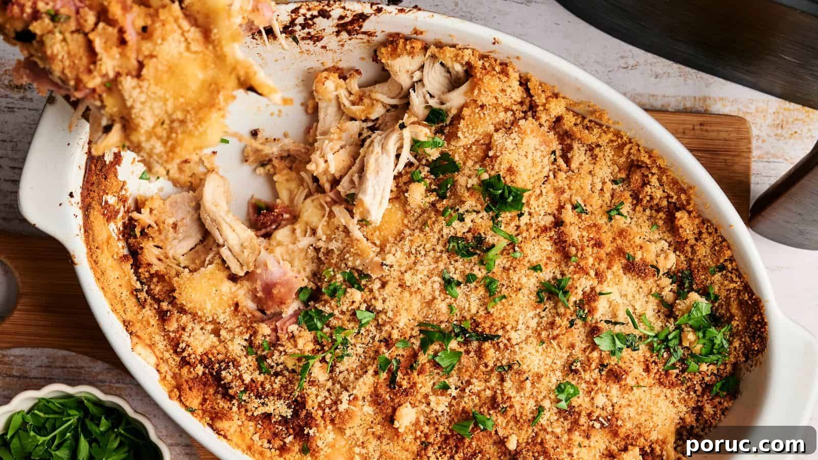 29 Air Fryer Casseroles Perfect for Busy Weeknight Dinners 12 Baked breadcrumb-topped casserole with pieces of chicken, garnished with chopped parsley in a white dish.