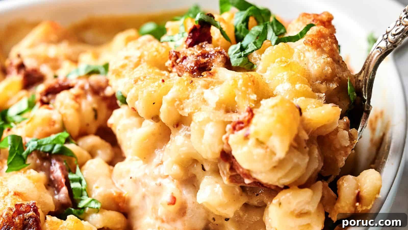 29 Air Fryer Casseroles Perfect for Busy Weeknight Dinners 14 Close-up of creamy macaroni and cheese with crispy topping, garnished with chopped green herbs and pieces of sun-dried tomatoes.