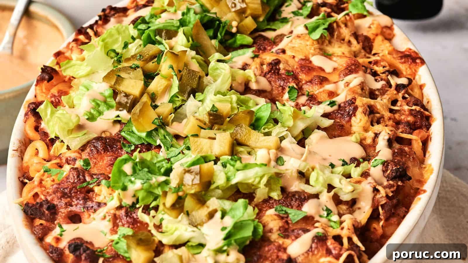 29 Air Fryer Casseroles Perfect for Busy Weeknight Dinners 15 An air fryer hamburger casserole emerges from the kitchen, a baked dish topped with melted cheese, lettuce, pickles, and sauce in a round baking dish gracing the table.