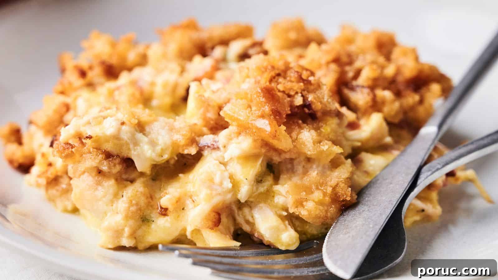29 Air Fryer Casseroles Perfect for Busy Weeknight Dinners 19 A plate of creamy macaroni and cheese topped with a crispy breadcrumb crust, with a fork and knife resting on the plate.