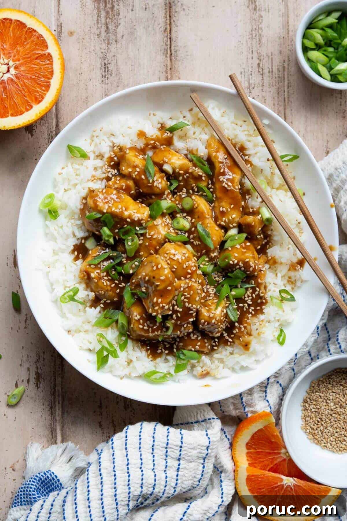 Crispy Air Fryer Orange Chicken Recipe You’ll Love 2 Healthy, sticky, and crispy air fryer orange chicken on a bed of rice with sesame seeds and green onion.