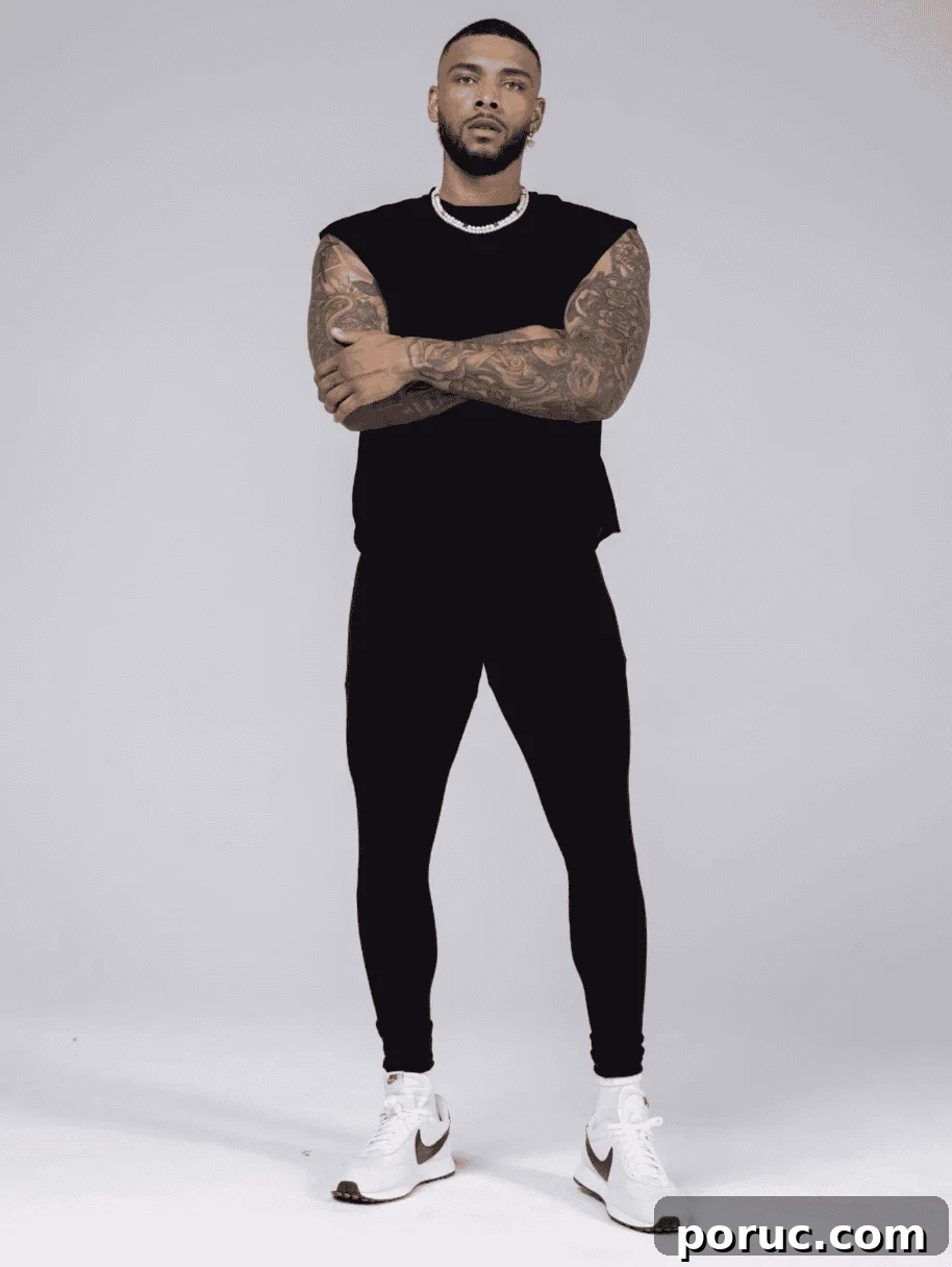 A tattooed male model wearing Allwear matching black leggings.