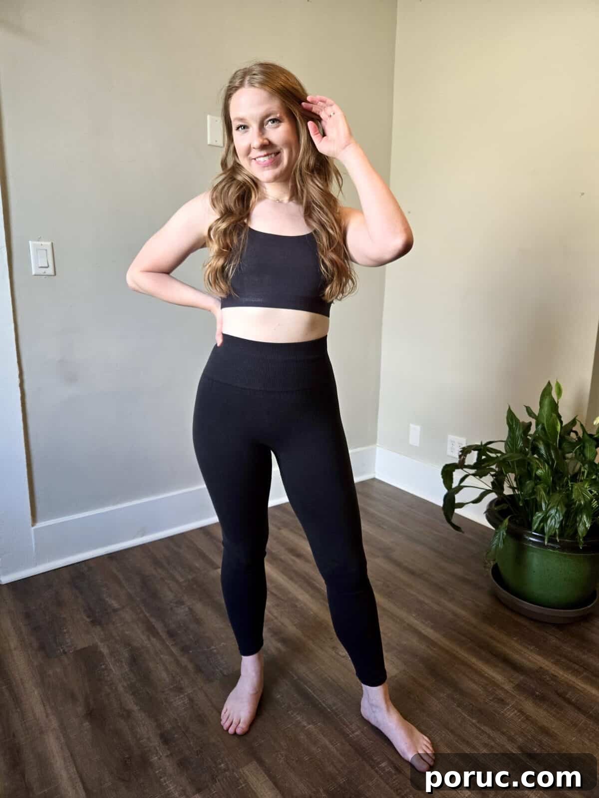 A woman wearing Organic Basics black ribbed tank and leggings.