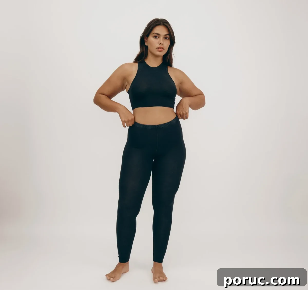 A woman wearing Organic Basics black cropped tank and leggings.