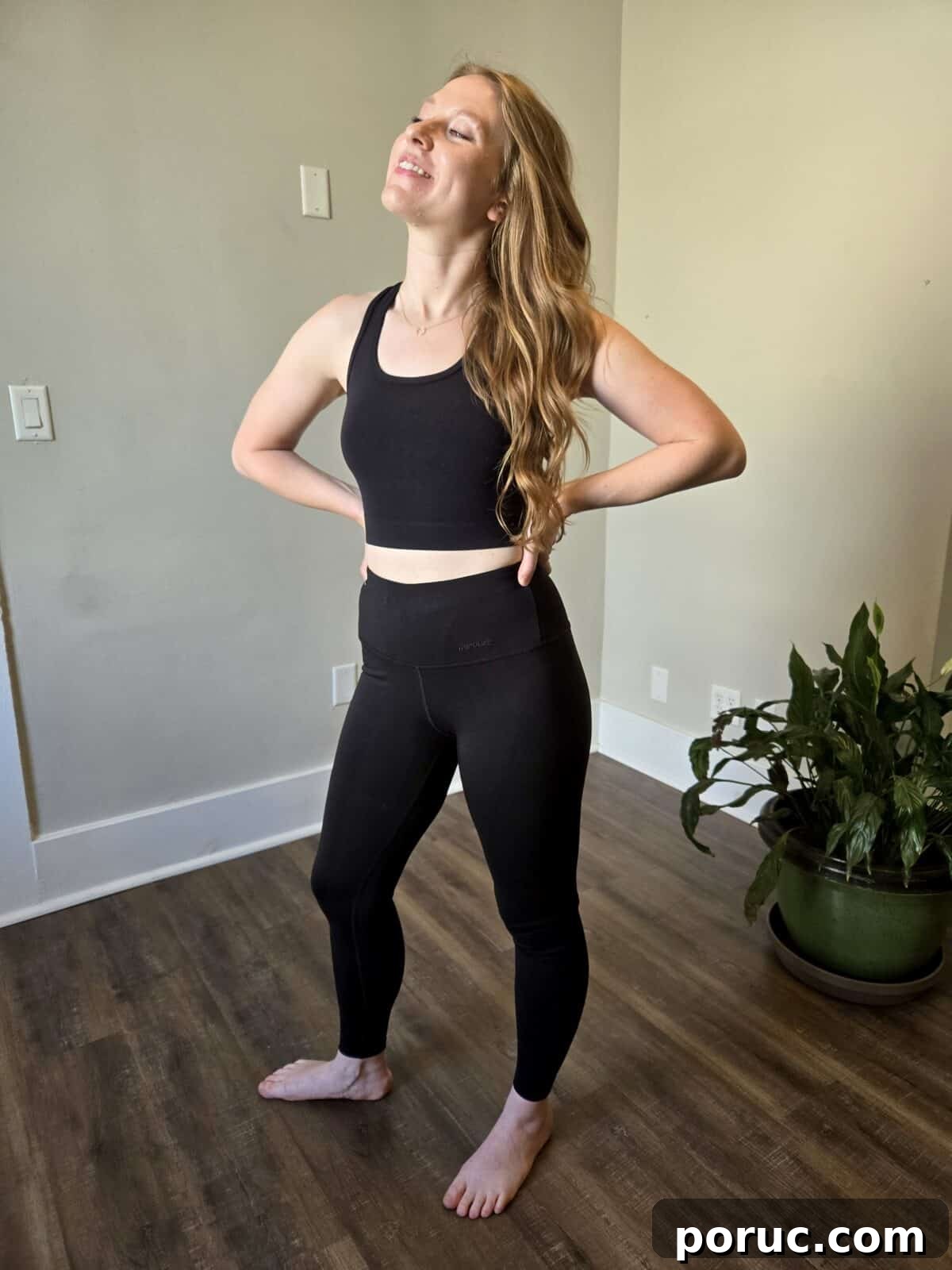 A smiling woman in high-waisted black leggings from Tripulse.